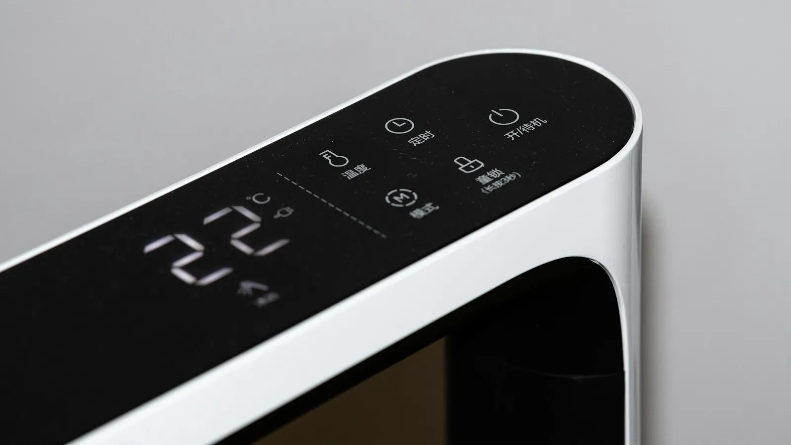 Digital control panel showing 22 degrees on a white appliance
