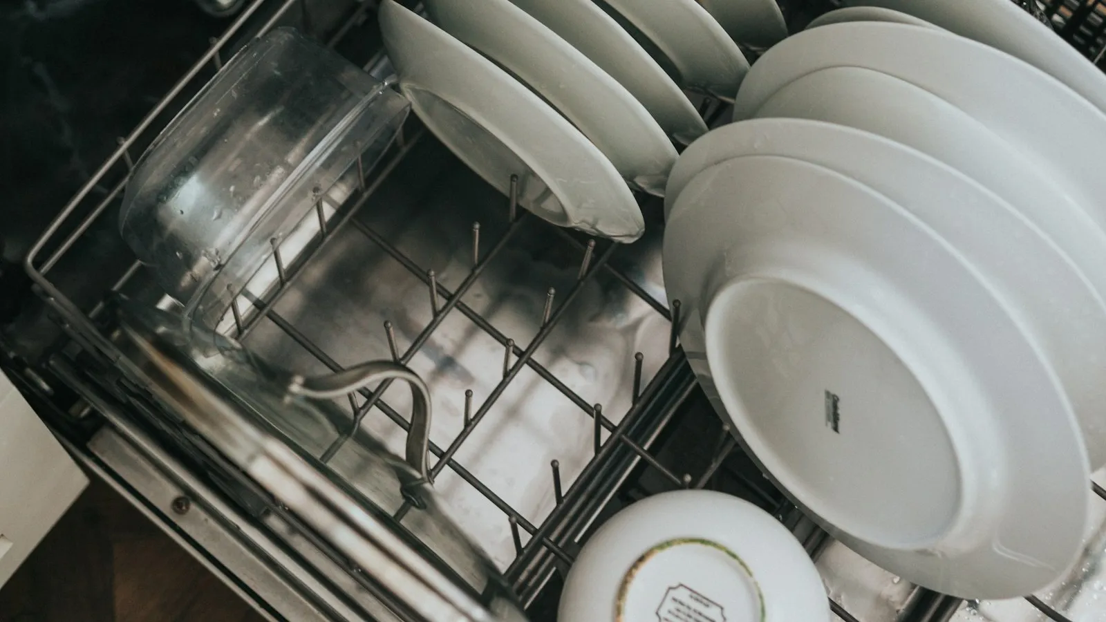 Open dishwasher with plates in the rack