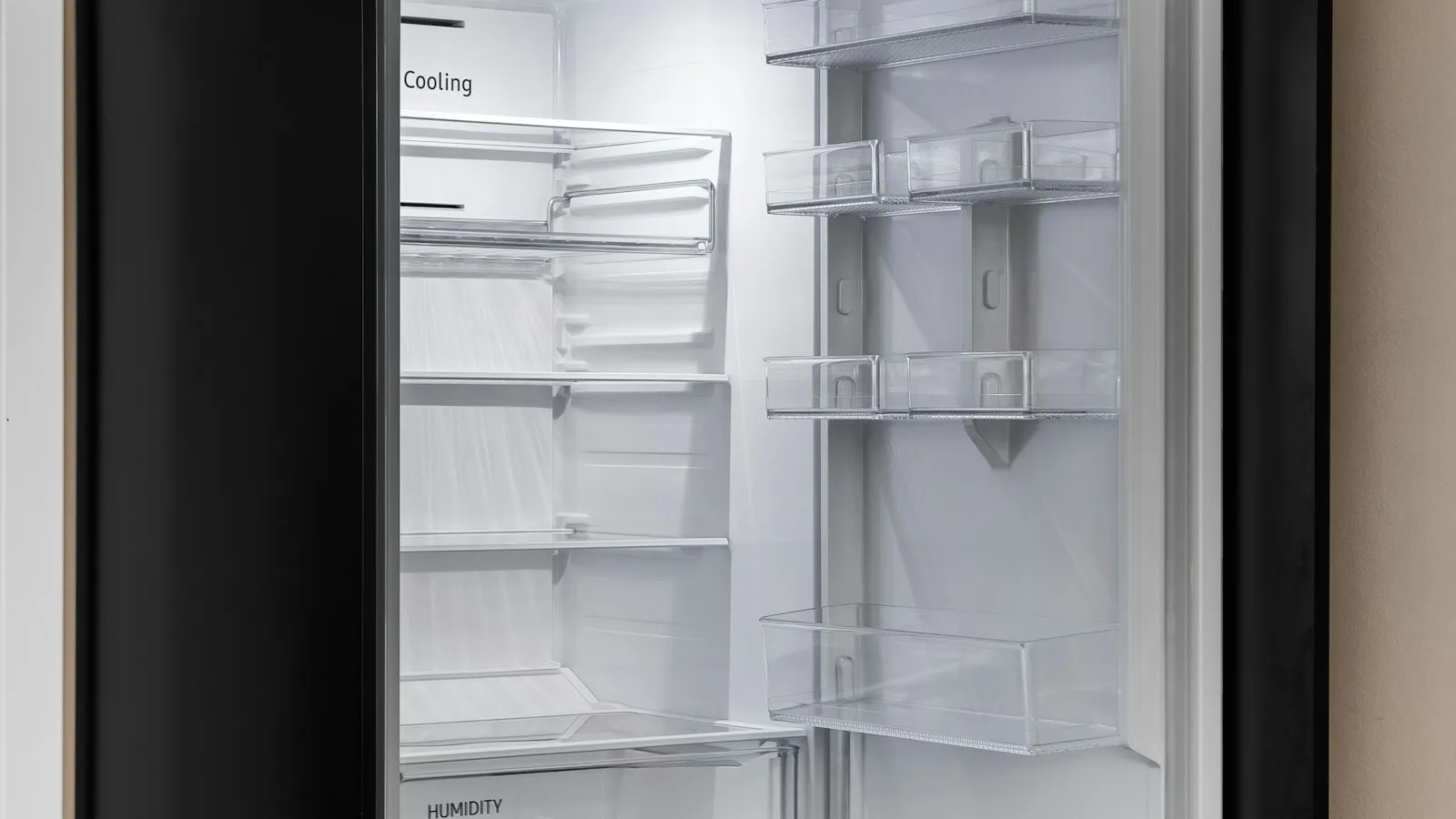 A black refrigerator with its door open in a kitchen
