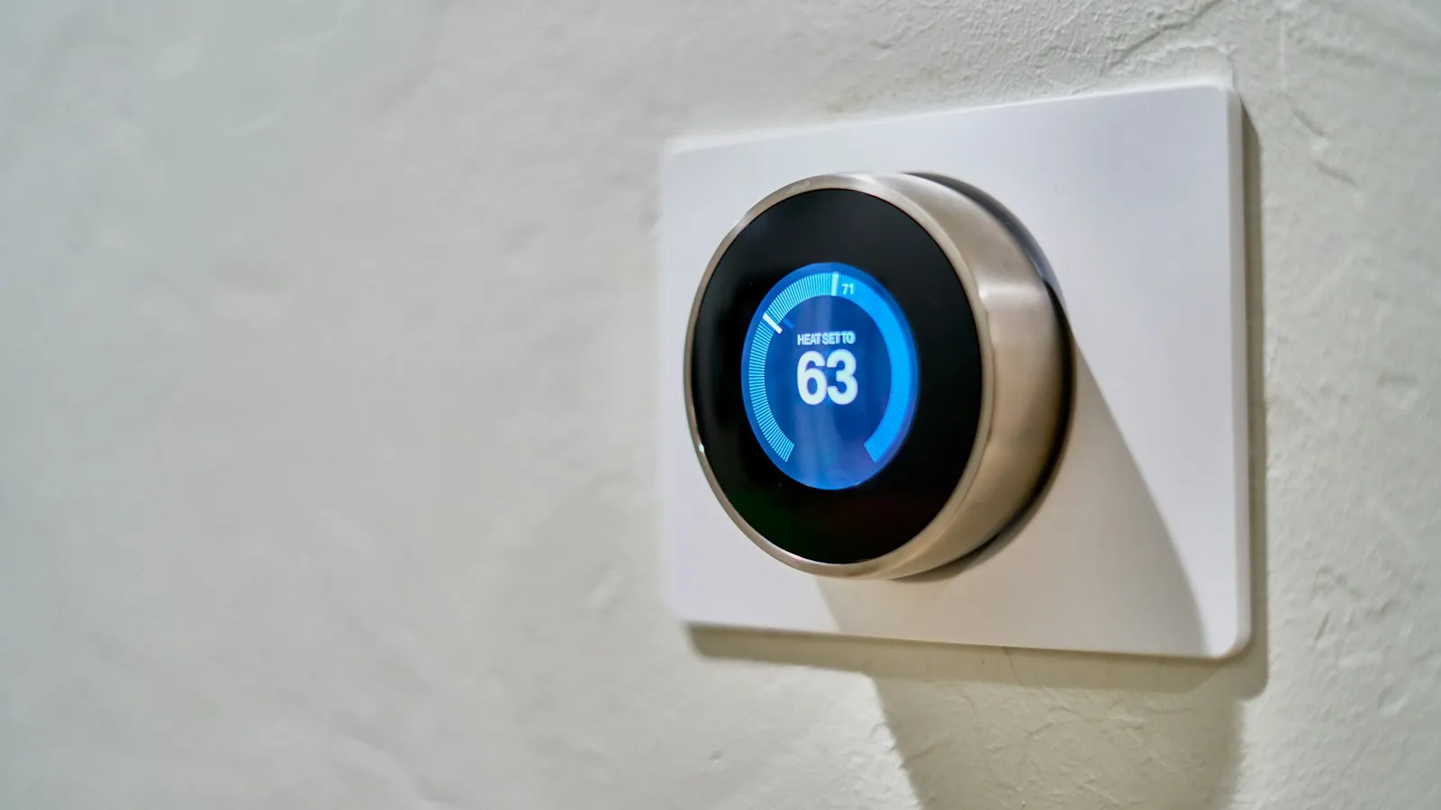 A thermostat on a wall showing the room temperature