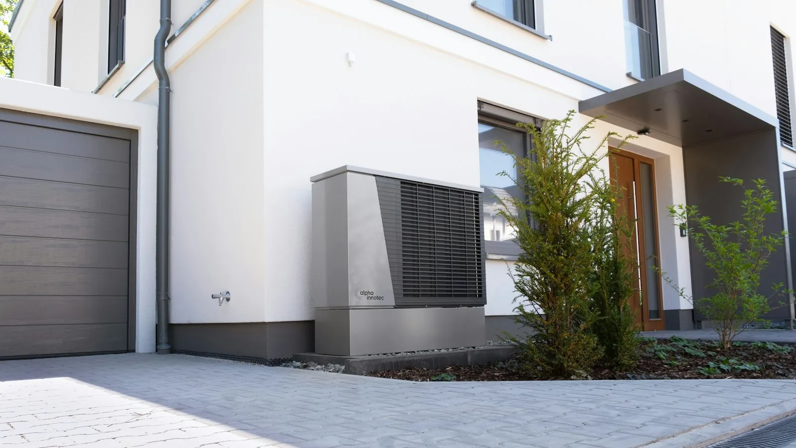 Outdoor heat pump unit beside a modern house