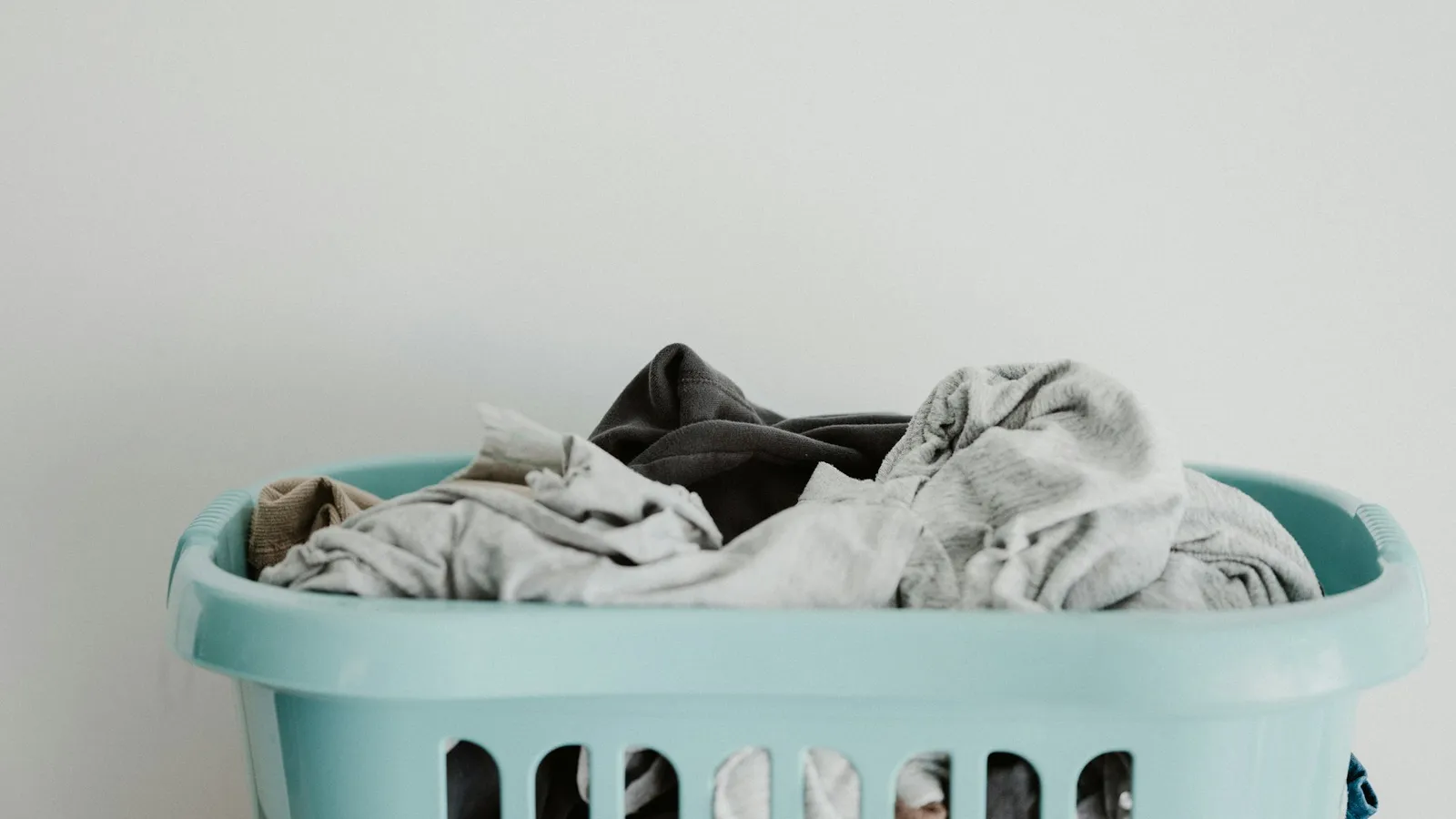 White towels in a blue plastic laundry basket