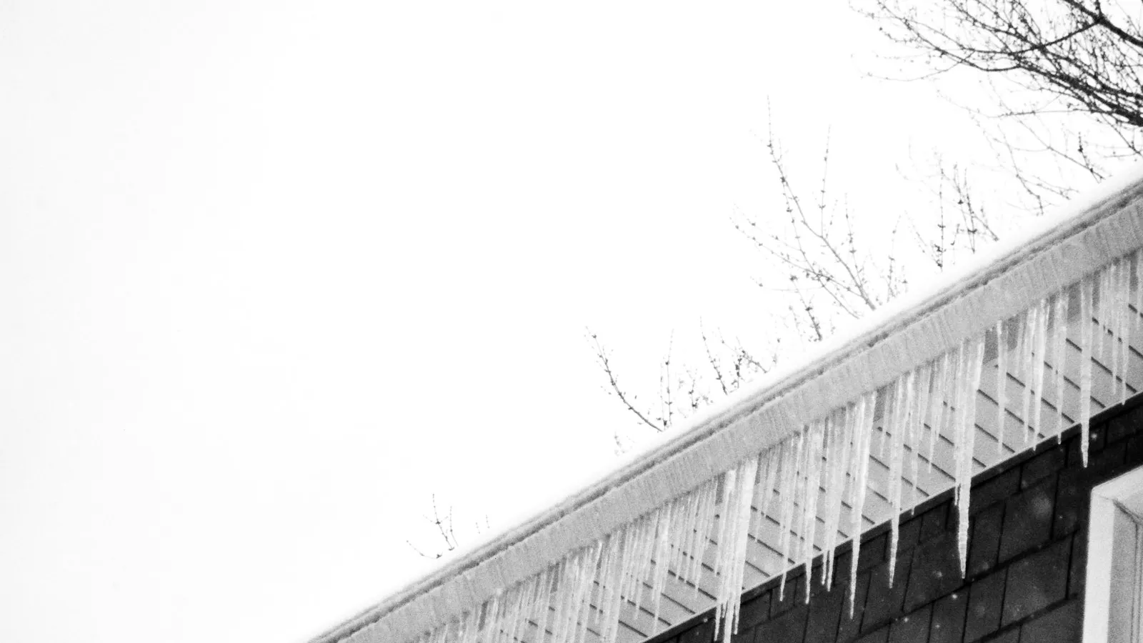 House roof covered with snow and icicles