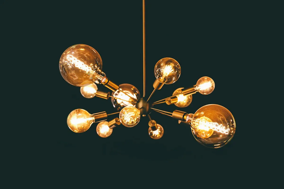 A chandelier with several exposed amber light bulbs