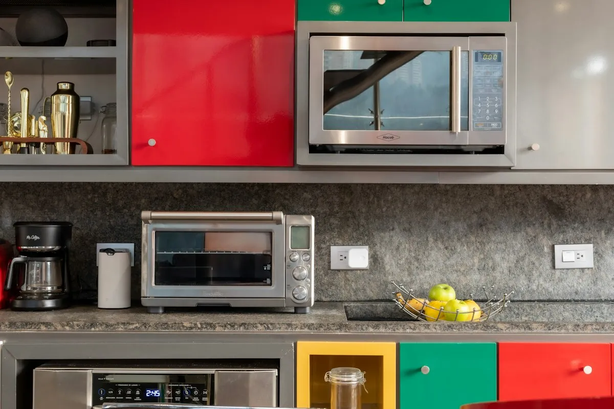 A kitchen counter with a toaster oven, a coffee maker and a microwave above