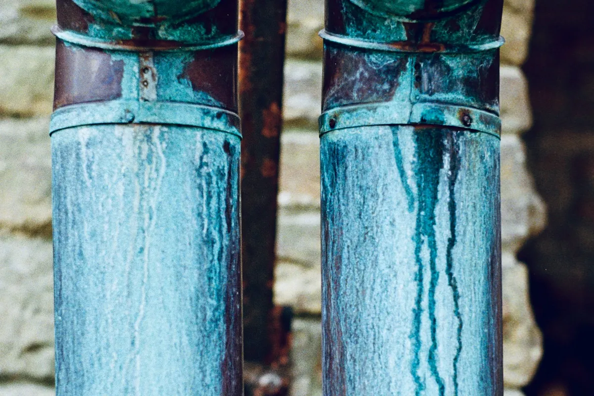 Two pipes against a brick wall