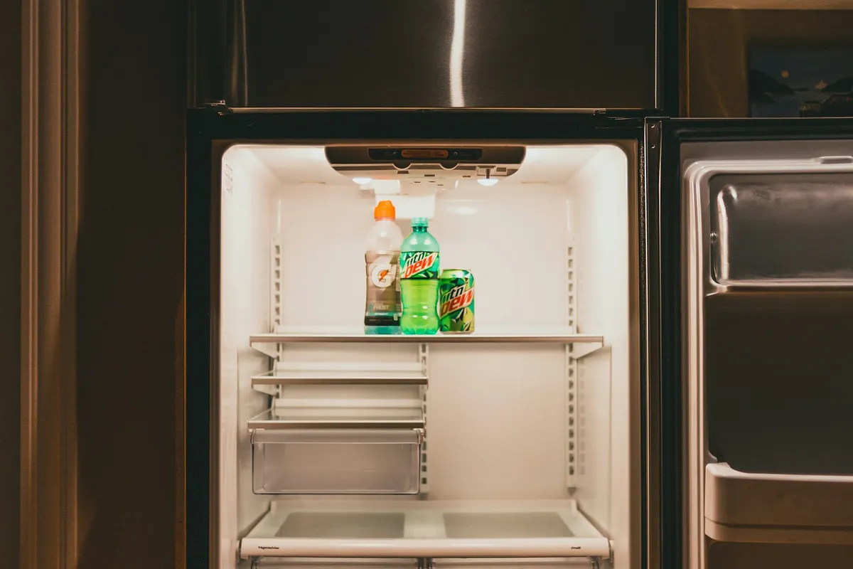 An open refrigerator with shelves and drinks