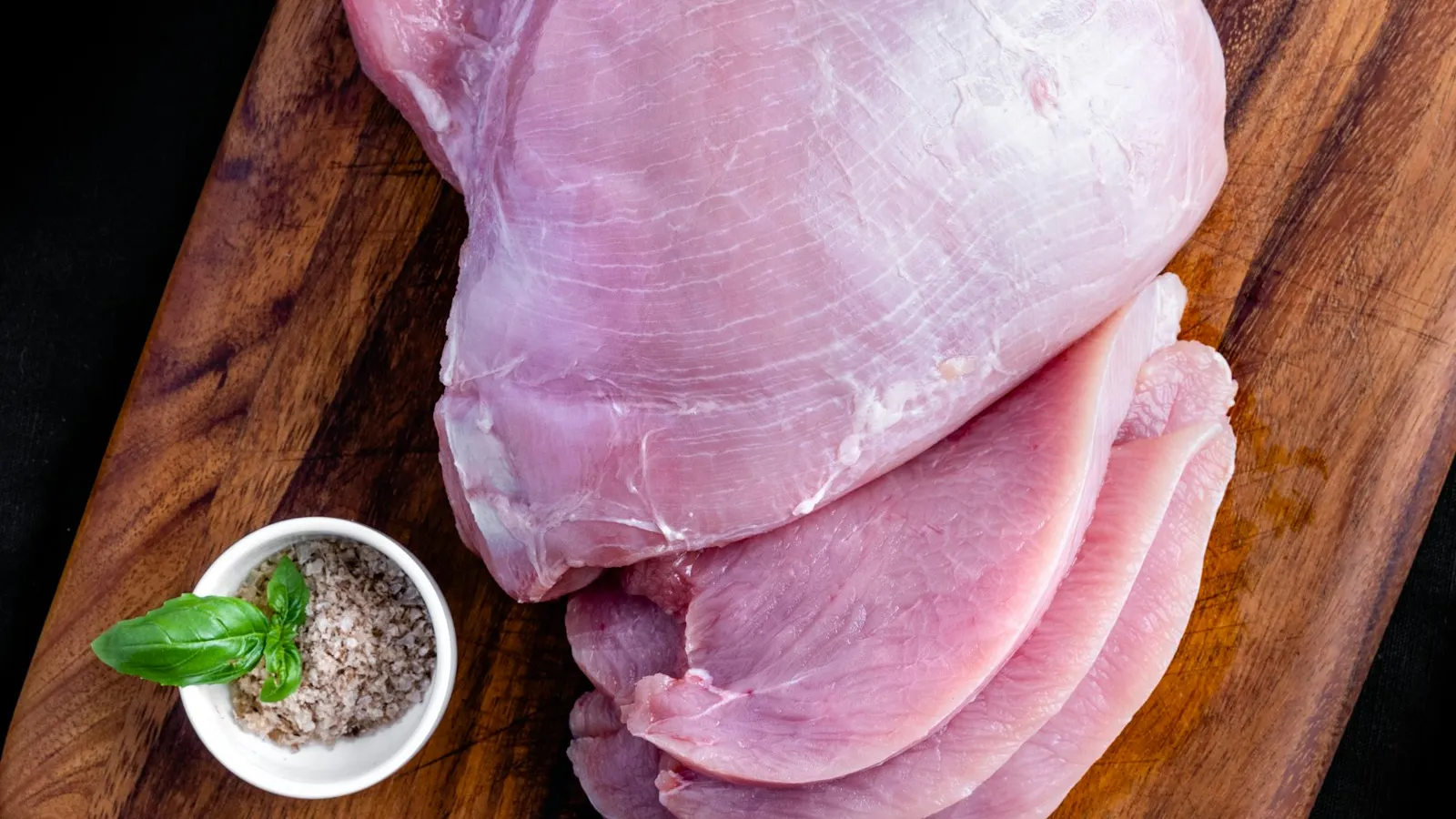 Raw turkey meat on a wooden board