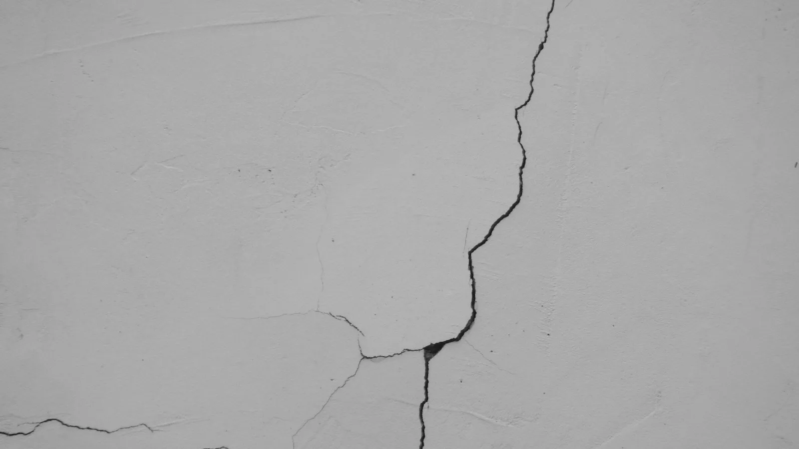 Long crack running across a white plaster wall