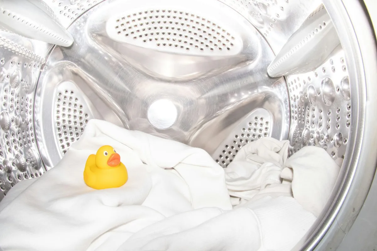 A rubber duck on laundry inside a washing machine drum