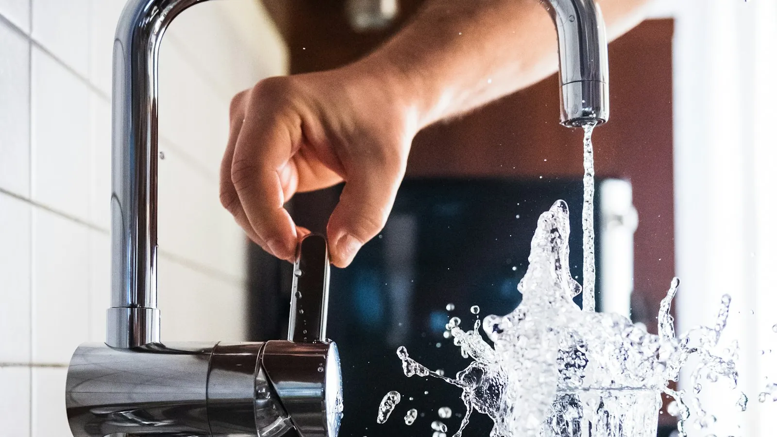 Hand under a running kitchen tap