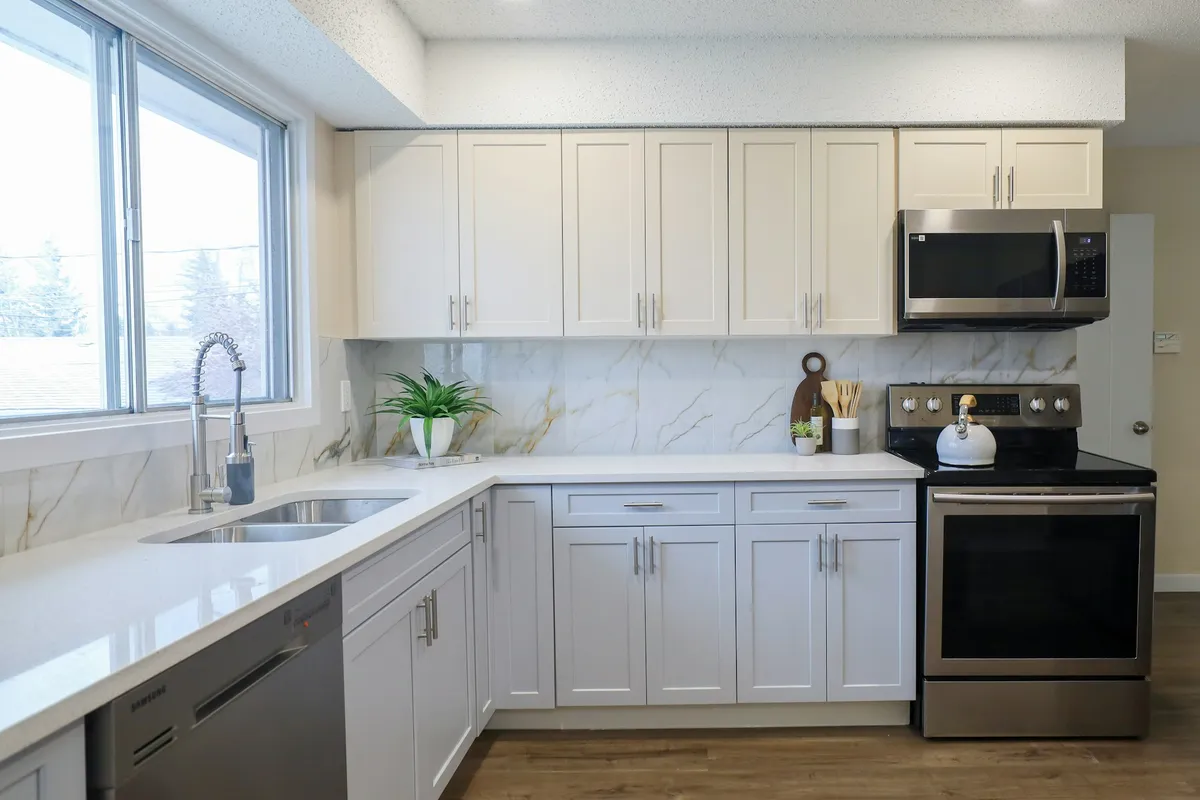 A modern kitchen with white cabinets and stainless steel appliances