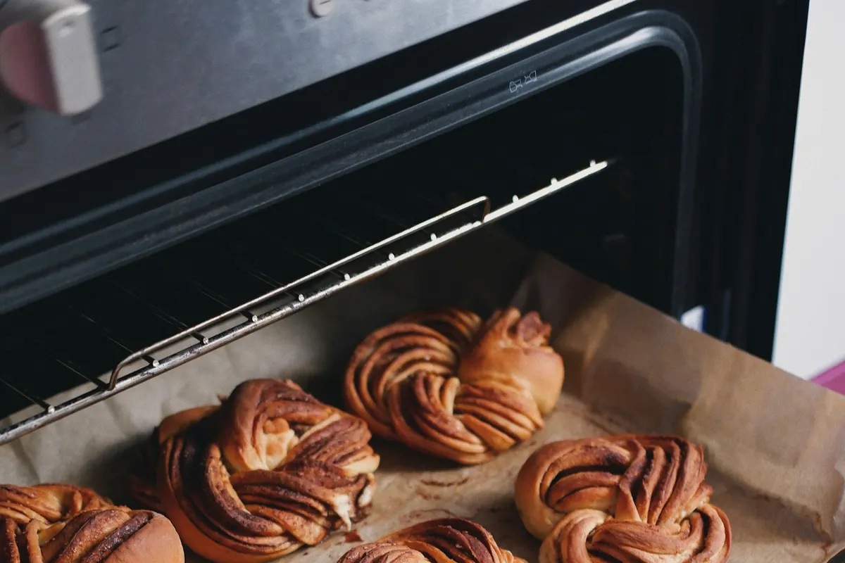 A tray of baked pastries on parchment inside an oven