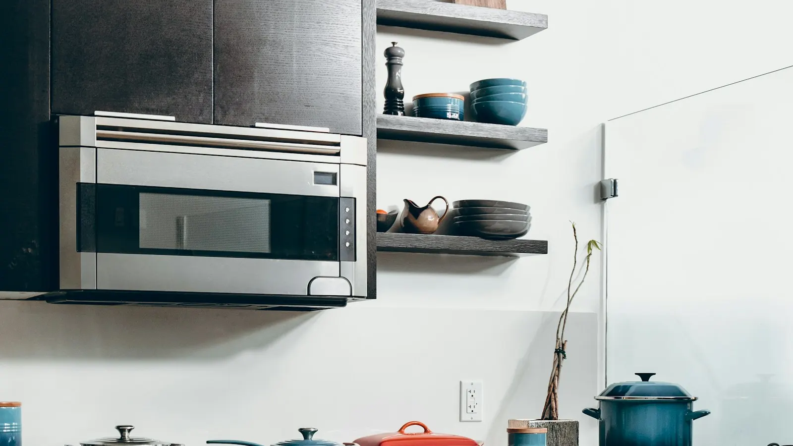 A stainless steel range with a closed oven door and pots on the stovetop