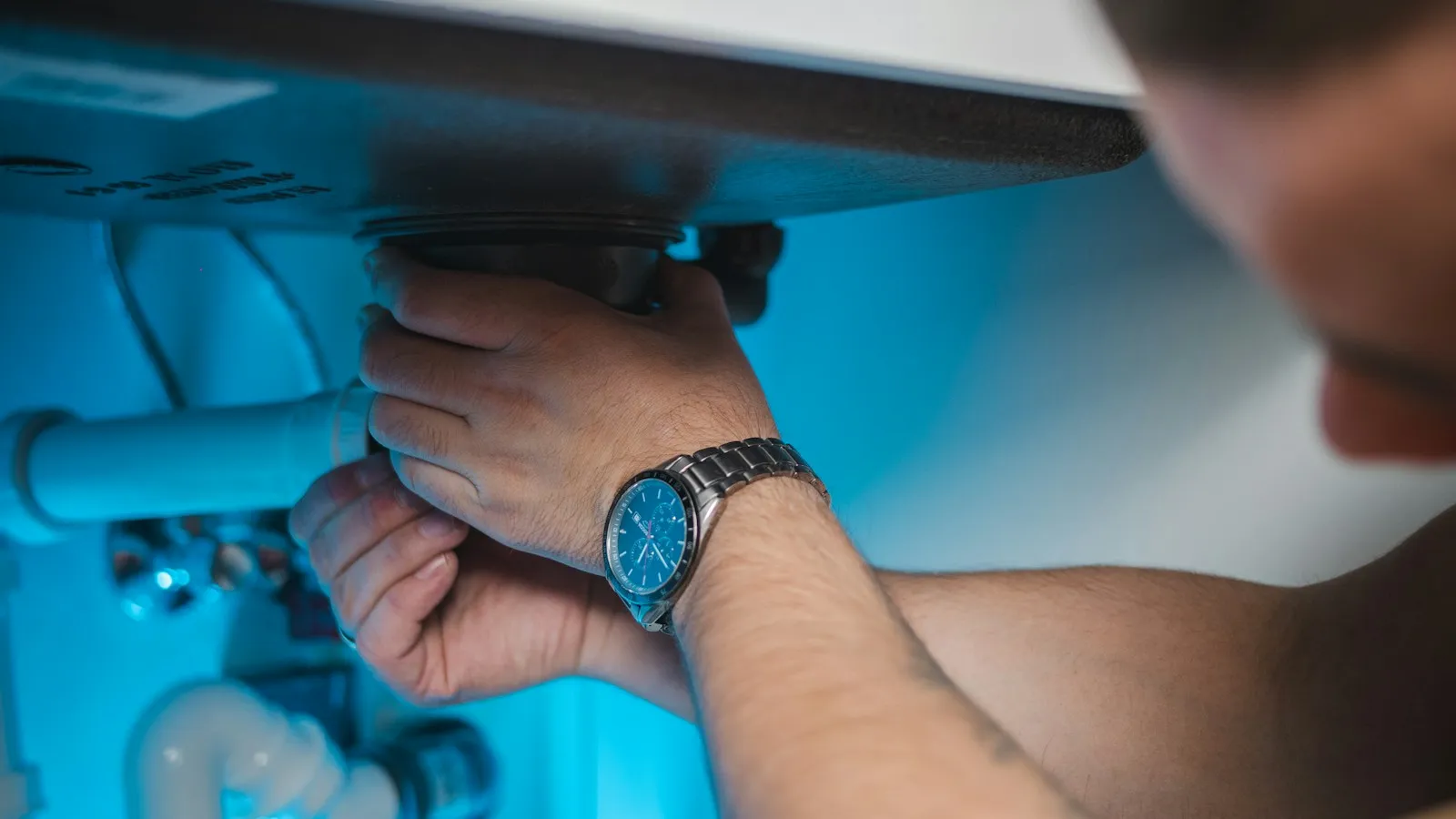 Man working on the water pipes and fittings of a water heater